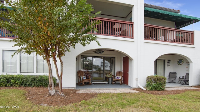 rear view of house with a yard and a balcony