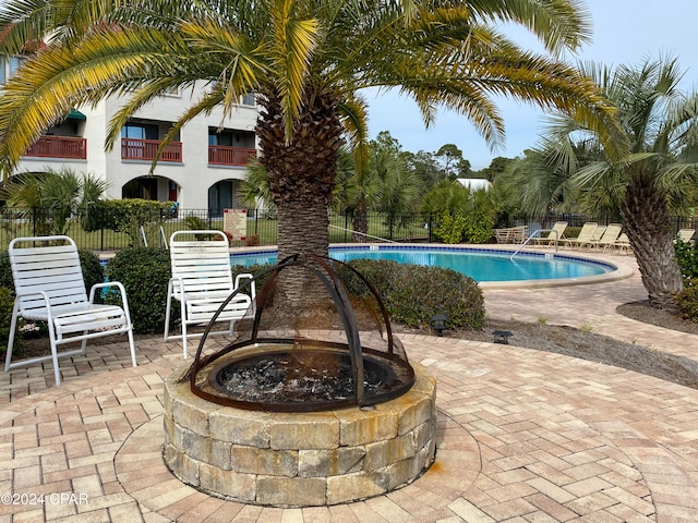 view of swimming pool with a fire pit and a patio area