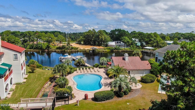 view of pool with a lawn, a water view, and a patio