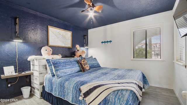 bedroom with ceiling fan, wood-type flooring, a textured ceiling, and ornamental molding