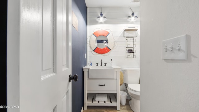 bathroom with vanity, toilet, and hardwood / wood-style floors