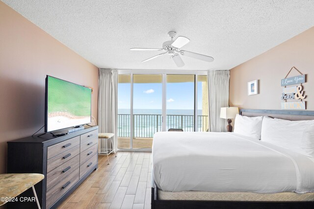 bedroom with ceiling fan, floor to ceiling windows, a textured ceiling, access to outside, and light wood-type flooring