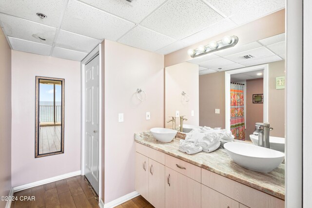 bathroom featuring hardwood / wood-style flooring, a paneled ceiling, and vanity