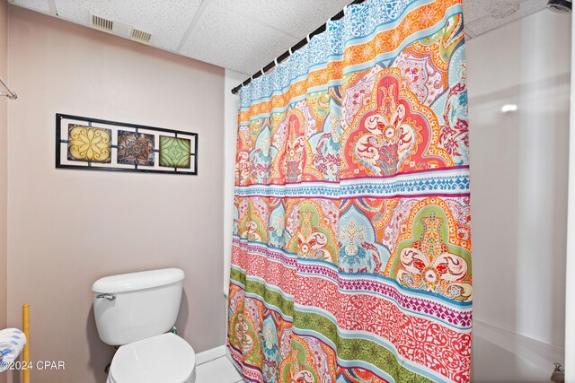 bathroom with curtained shower, a paneled ceiling, and toilet