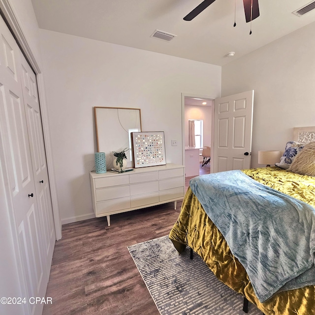 bedroom with ceiling fan, dark wood-type flooring, and a closet