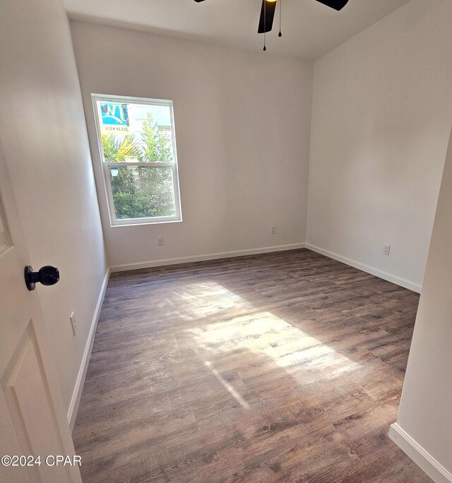 empty room with ceiling fan and dark wood-type flooring