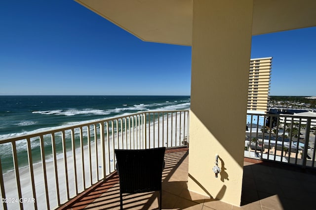 balcony featuring a water view and a beach view