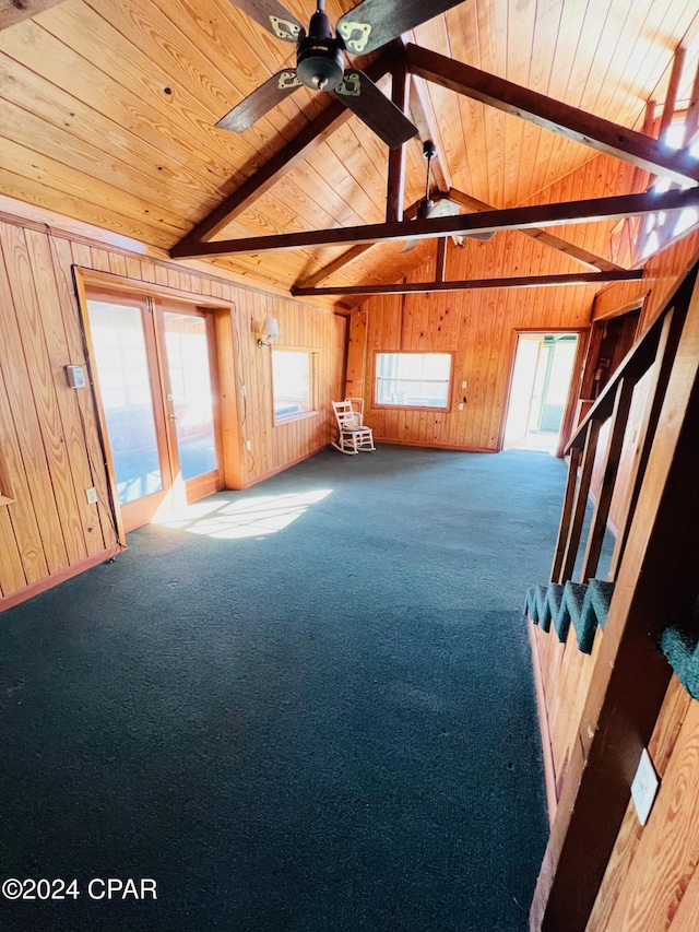 interior space with vaulted ceiling with beams, plenty of natural light, carpet, and wood ceiling