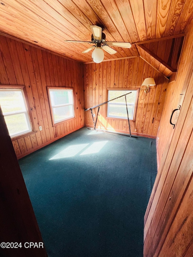 unfurnished room with ceiling fan, wooden walls, carpet, and wooden ceiling