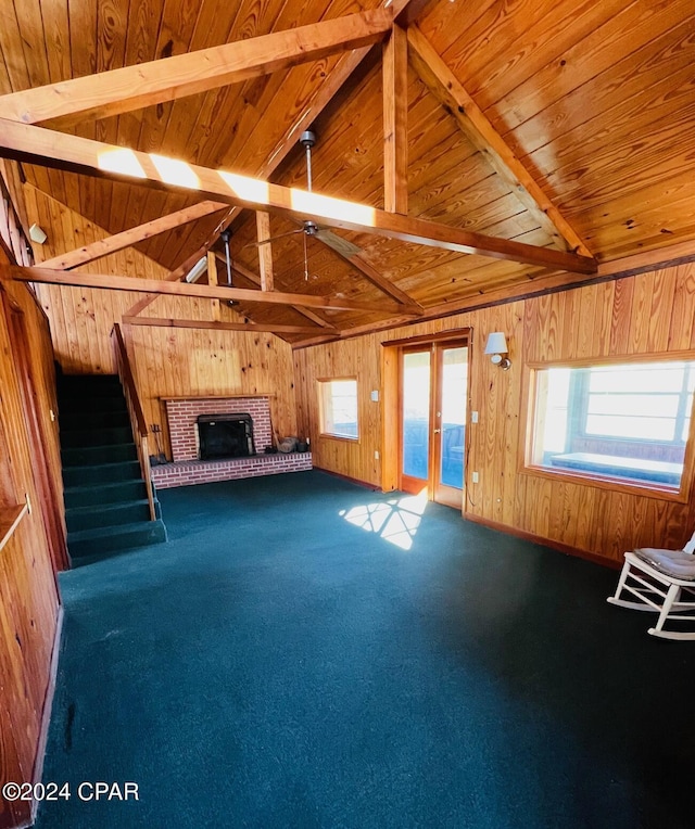 unfurnished living room featuring carpet flooring and wood walls