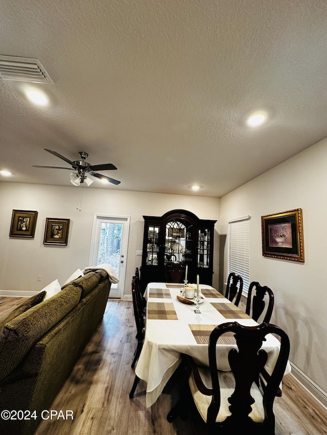 dining room with hardwood / wood-style flooring, ceiling fan, and a textured ceiling