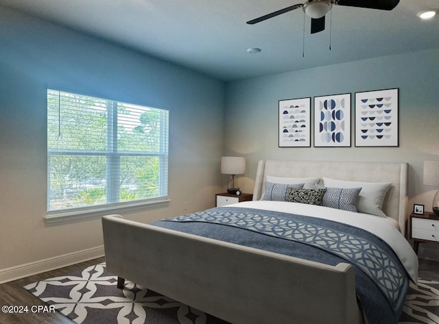 bedroom featuring hardwood / wood-style flooring, multiple windows, and ceiling fan