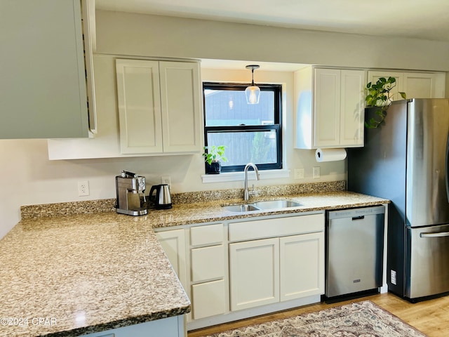 kitchen with white cabinetry, sink, stainless steel appliances, and light wood-type flooring