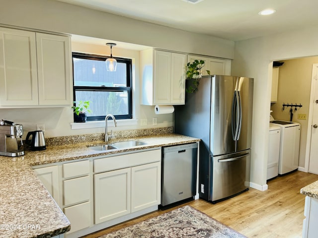 kitchen with white cabinets, washer and dryer, sink, and stainless steel appliances