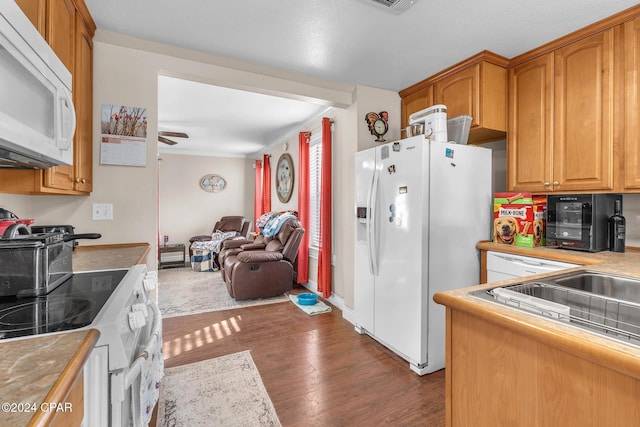 kitchen with dark hardwood / wood-style floors, ceiling fan, white appliances, and ornamental molding