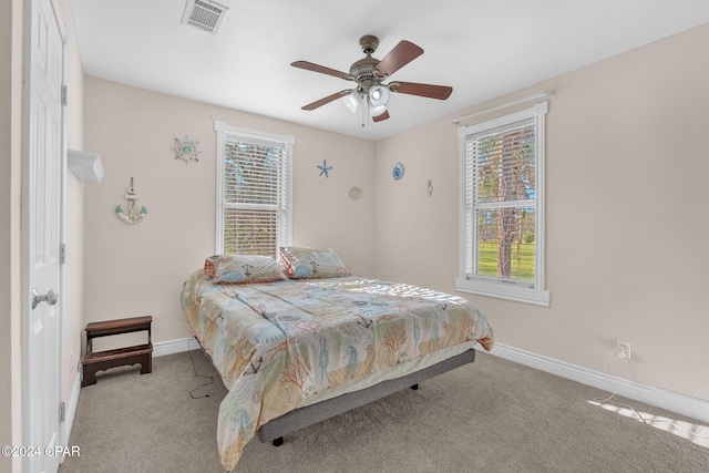 bedroom featuring multiple windows, ceiling fan, and light colored carpet