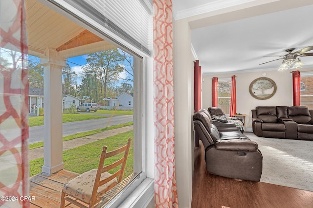 living room with wood-type flooring, ceiling fan, and ornamental molding