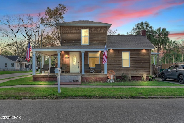 view of front facade with a porch and a lawn