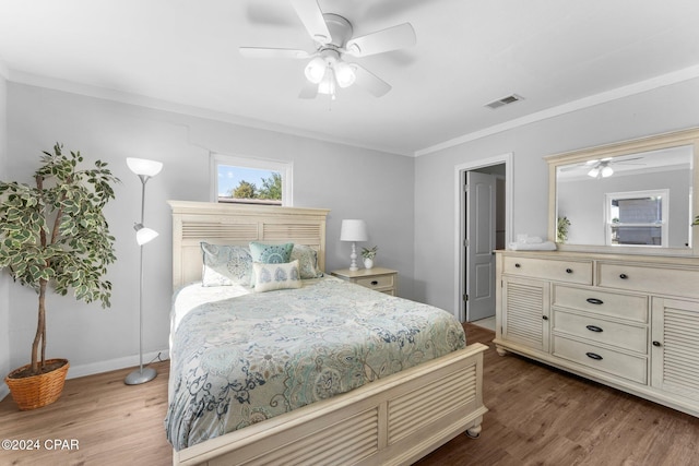 bedroom featuring hardwood / wood-style flooring, ceiling fan, and crown molding