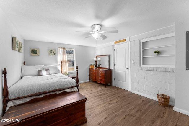 bedroom with ceiling fan, hardwood / wood-style floors, and a textured ceiling