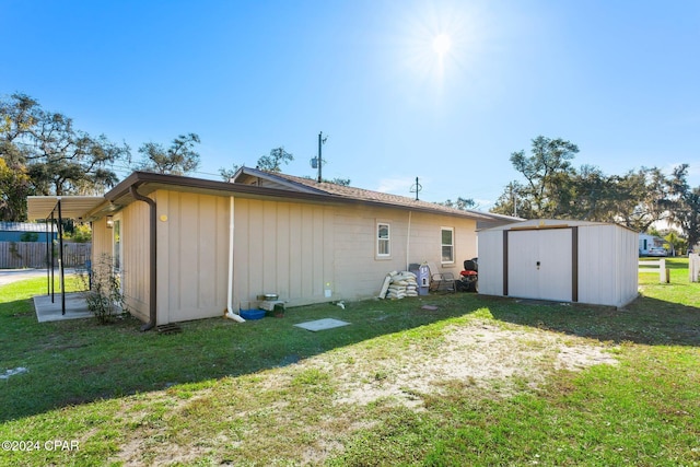 rear view of property with a storage unit and a lawn