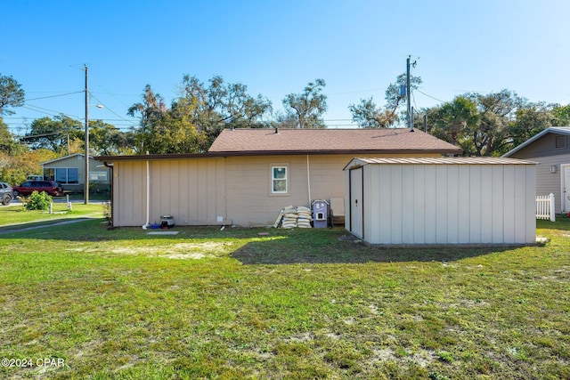 back of property with a yard and a shed