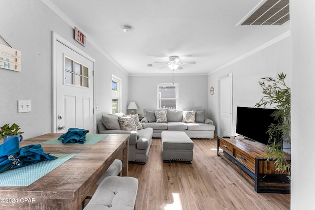 living room with crown molding, ceiling fan, and light wood-type flooring