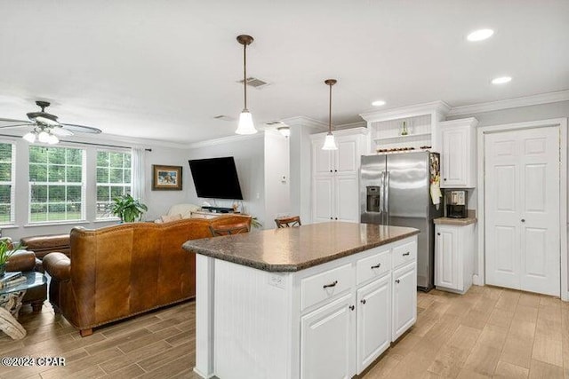 kitchen featuring hanging light fixtures, stainless steel refrigerator with ice dispenser, white cabinets, a kitchen island, and light wood-type flooring