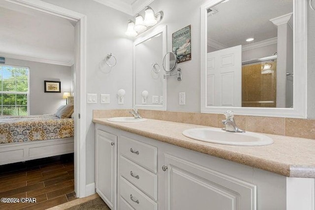 bathroom with a shower with shower door, vanity, and crown molding