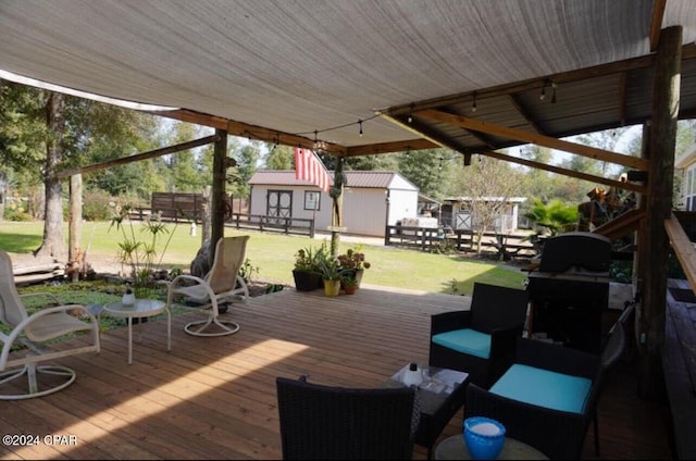 wooden terrace featuring an outbuilding and a lawn