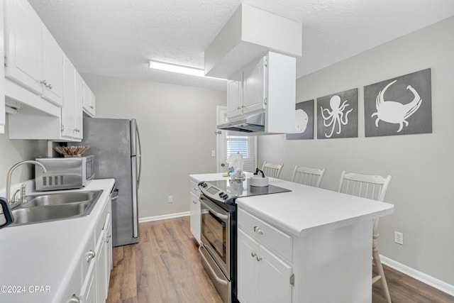 kitchen featuring white cabinets, a kitchen bar, hardwood / wood-style flooring, and stainless steel electric stove