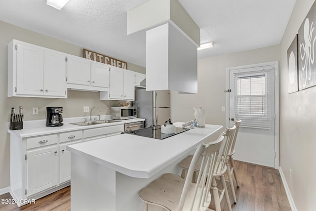 kitchen featuring appliances with stainless steel finishes, white cabinetry, and sink