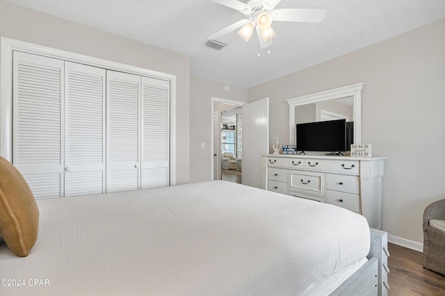 bedroom with dark hardwood / wood-style flooring, a closet, and ceiling fan