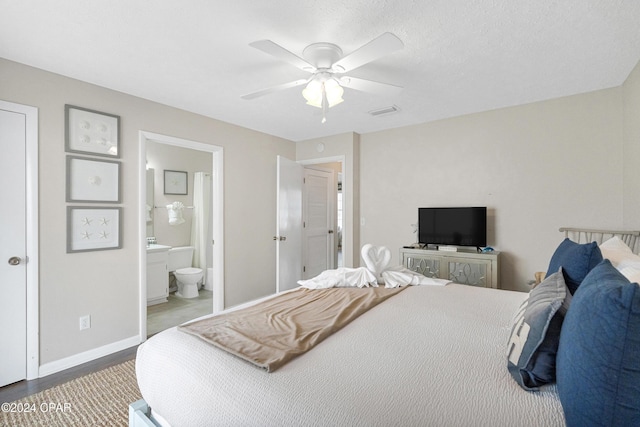 bedroom with hardwood / wood-style flooring, ceiling fan, a textured ceiling, and ensuite bath