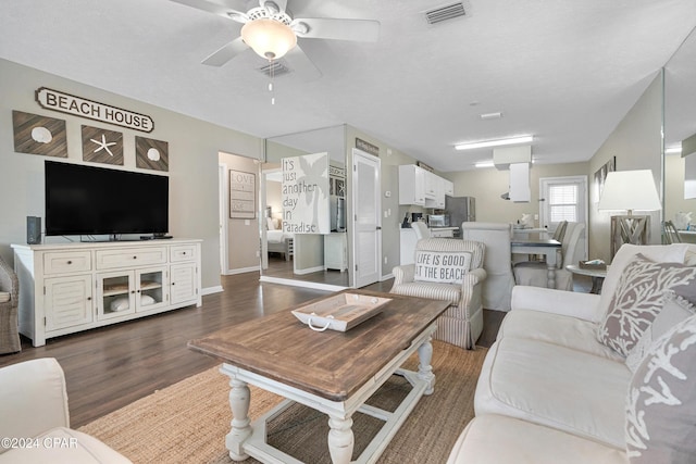 living room with ceiling fan and dark wood-type flooring