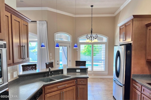 kitchen featuring backsplash, hanging light fixtures, sink, appliances with stainless steel finishes, and a notable chandelier