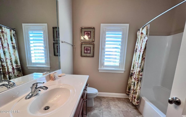 full bathroom with a wealth of natural light, shower / bath combo with shower curtain, vanity, and toilet