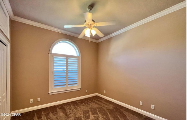 spare room with ceiling fan, dark carpet, and crown molding