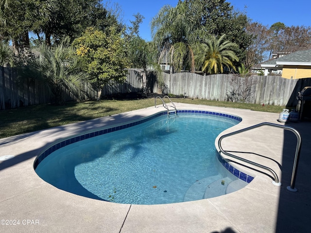 view of swimming pool with a lawn