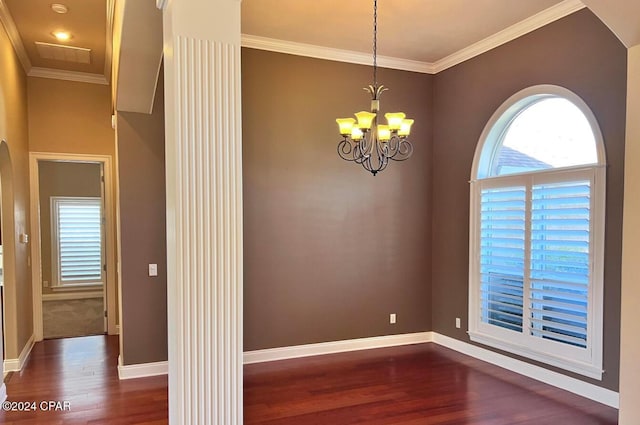 spare room with a chandelier, ornamental molding, and dark wood-type flooring