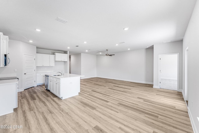 kitchen with white cabinets, light hardwood / wood-style floors, stainless steel appliances, and an island with sink