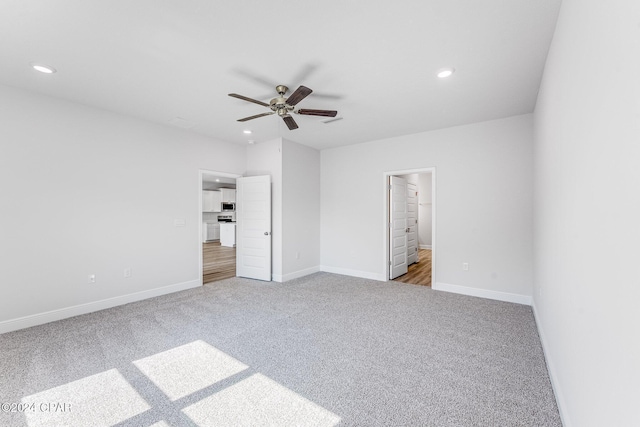 unfurnished bedroom featuring carpet floors, a spacious closet, a closet, and ceiling fan