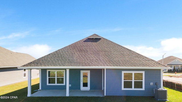 rear view of house with a yard, a patio, and central AC unit