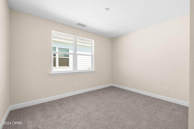 carpeted empty room with visible vents and baseboards