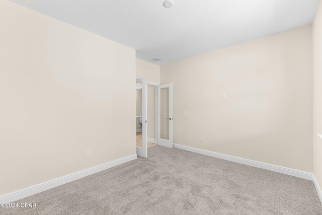 spare room featuring visible vents, baseboards, and carpet floors