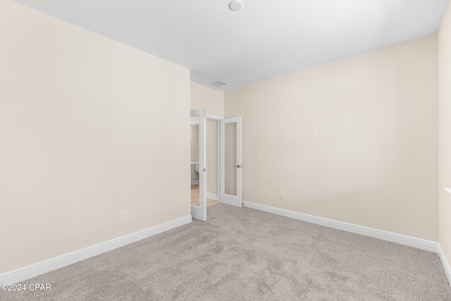 spare room with baseboards, carpet flooring, and visible vents