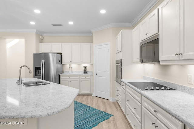 kitchen featuring visible vents, ornamental molding, white cabinets, stainless steel appliances, and a sink