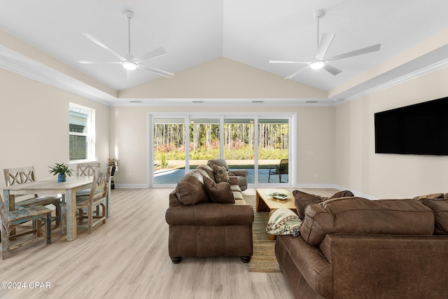 living room with a wealth of natural light, a ceiling fan, light wood-style flooring, and lofted ceiling