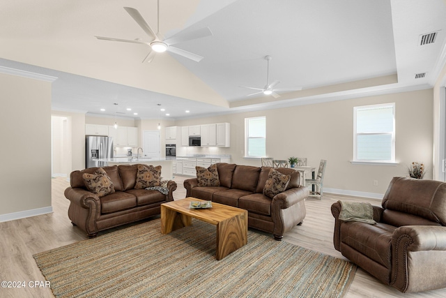 living area featuring visible vents, a ceiling fan, and light wood finished floors