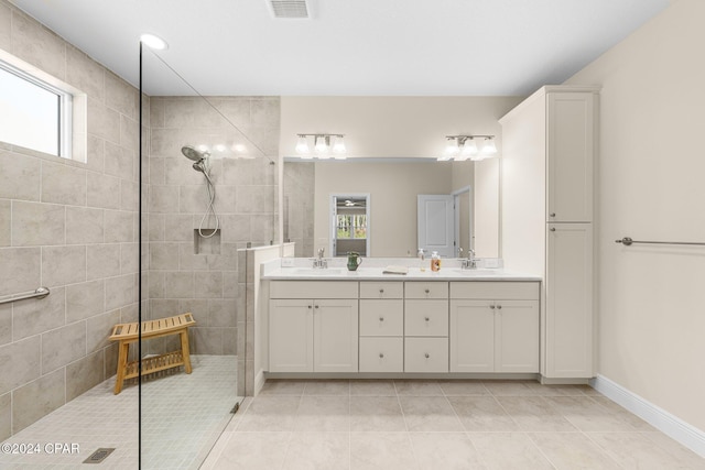 bathroom with double vanity, visible vents, a sink, and walk in shower